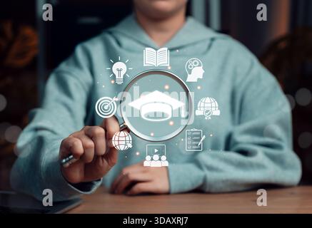 Online education and learning research concept with a magnifying glass focusing on graduation cap icon, symbolizing digital study, knowledge Stock Photo