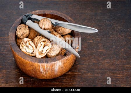 Walnuts and Nutcracker in Wooden Bowl, Healthy Snack, Autumn Harvest, and Rustic Still Life Stock Photo