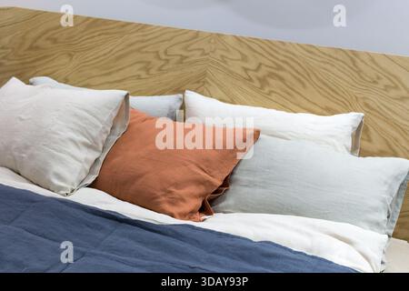 Decorative pillows on the bed close-up. A beautiful combination of natural fabrics Stock Photo