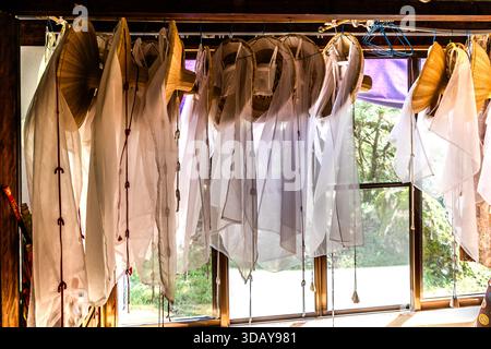 Straw hats with white veils hang in a kimono experience shop on the Kumano Kodo pilgrimage route in Nachikatsuura, Wakayama Prefecture, Japan. Stock Photo