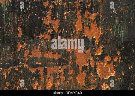 Detail of an old, oxidized metal sheet with black flaking paint Stock Photo