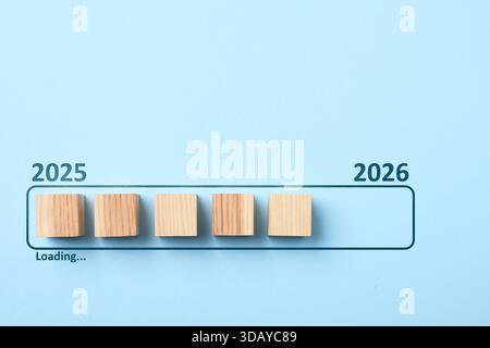 New Year 2026. Wooden cubes in loading bar on light blue background, top view Stock Photo