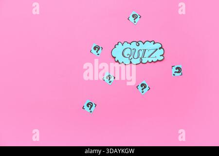 Word QUIZ in speech bubble with question marks on pink background Stock Photo