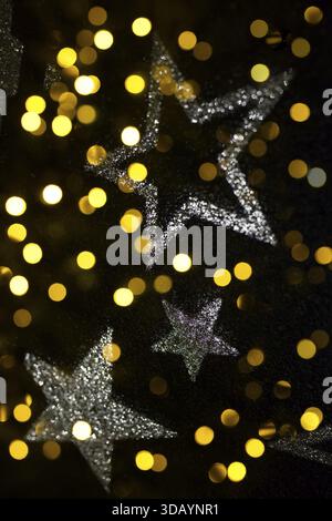 2x lighting, reflected star patterns on asphalt ground, bokeh light spots from Christmas lights, contemplative image, bright and golden, festive light Stock Photo