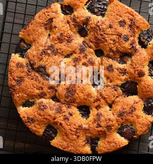 Plum pie on cooling rack on wooden table .Top view, flat lay Stock Photo