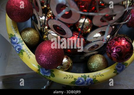 Red and gold Christmas bauble decorations at base of mini tree Stock Photo