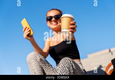 Mockup of brown paper coffee cup in hand of urban woman Stock Photo