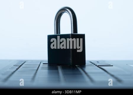 Padlock on a laptop keyboard. Digital security, data protection, and online safety concept. Stock Photo