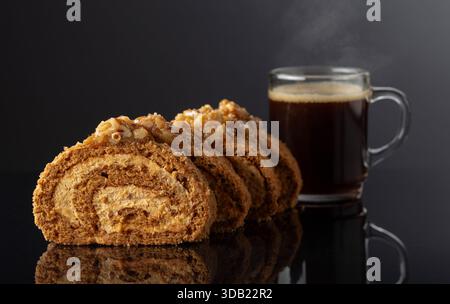 Walnut and buttercream roll: a traditional Oriental pastry. Dessert with walnuts and coffee on a black reflective background. Copy space. Stock Photo