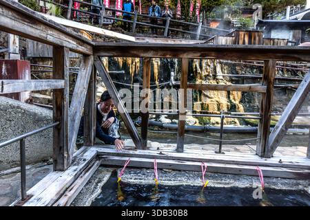 A woman cooking tamago onsen at the yuzutsu (public cooking area) in the centre of Yunomine Onsen. People have been using the hot springs for cooking since at least the Edo period (1603 to 1868). Tanabe, Wakayama Prefecture, Japan Stock Photo