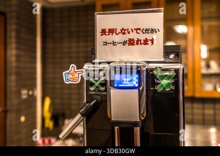 A Japanese fully automatic coffee machine carries a sign warning that the button must not be held down, or coffee will overflow. Hongucho Wataze, Tanabe, Wakayama Prefecture, Japan. Stock Photo