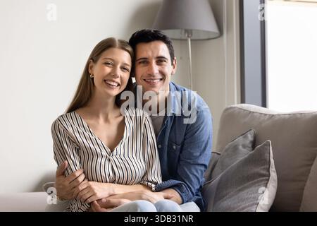 Portrait of young homeowner family sitting on sofa Stock Photo