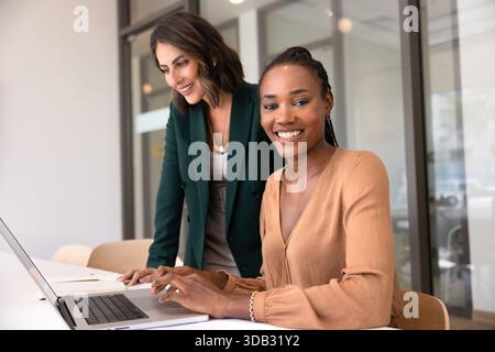 Happy young African American professional woman working at computer Stock Photo