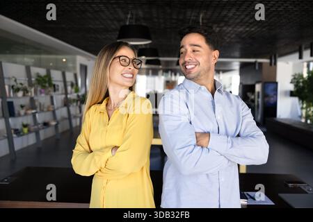 Two happy young diverse business partners standing close together Stock Photo