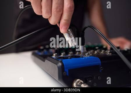 Fitting cables into professional studio gear, Attaching connectors carefully on live music setup, Ensuring accurate cable connections on audio Stock Photo