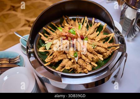 Golden fried shrimp with garnishes, Crispy seafood served with lemon and herbs, Delicious crispy fried shrimp arranged beautifully with lemon slices Stock Photo