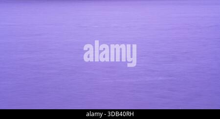 Long exposure abstract of calm water creating a smooth purple surface Stock Photo