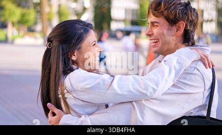 Happy diverse couple embracing outdoors enjoying inclusion Stock Photo