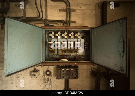 Open vintage electrical control panel in abandoned paper mill Stock Photo