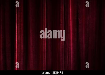Dark red velvet curtain, full frame background texture, concept for theater, performances, and festive events, copy space, selected focus Stock Photo