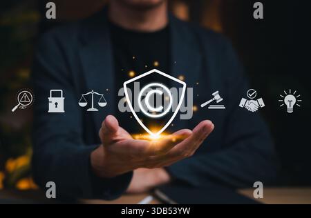 Copyright protection concept. Person holding copyright icon with legal, security, and intellectual property symbols, representing creative rights, Stock Photo
