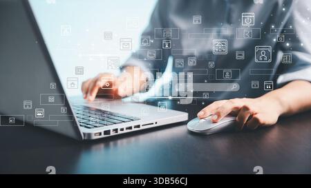 A person using a laptop and computer mouse with floating digital interface icons, representing online technology, data management, web applications an Stock Photo