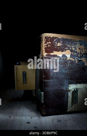 Damaged dark synthetic leather sofa. Old cracked damaged leather on synthetic leather sofa upholstery. Stock Photo