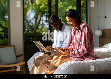Couple of freelance IT specialists using digital technology devices while working remotely from home Stock Photo