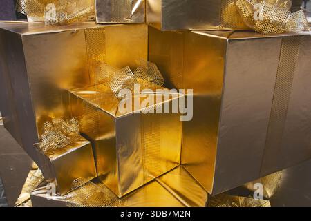 A view of a stack of gold wrapped gifts. Stock Photo