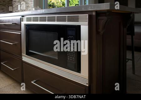 A view of a built-in microwave appliance in a kitchen setting. Stock Photo