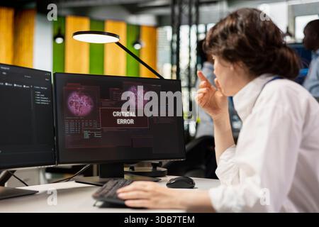 Startup office software developer doing debugging on PC, fixing malfunctions. IT professional at work repairing coding mistakes using computer monitor, doing quality assurance Stock Photo