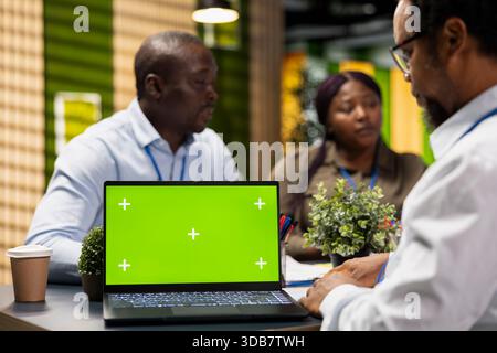 Green screen laptop used by Silicon Valley company IT staff members in office developing software apps. Mockup notebook used by coworkers to code, debugging applications to resolve issues Stock Photo