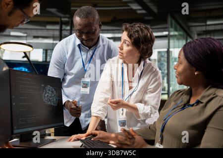 Engineering team working together, running AI algorithms on PC in startup workspace. Teamworking colleagues using artificial intelligence deep learning coding platform on computer Stock Photo