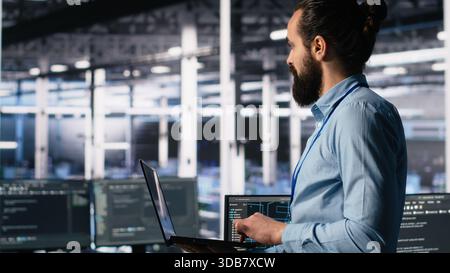 Server hub admin using AI LLM chatbot to review hardware diagnostics. IT expert in data center using artificial intelligence large language model to analyze performance data, handheld camera shot Stock Photo