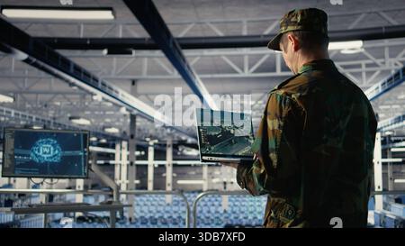 Military data center expert using ballistic missiles radar on laptop to watch for enemy threats. Army soldier in data center uses scanner tech to detect rockets launched by enemy troops, camera A Stock Photo