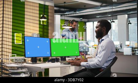 Technician using green screen PC to code AI algorithms debugging software issues and improving system stability. IT specialist in tech startup office using mockup computer, camera A Stock Photo