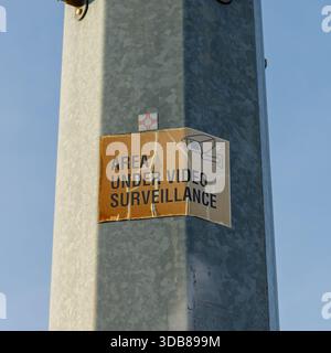 Warning sign indicating an area under video surveillance on a galvanized pole Stock Photo