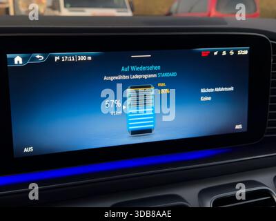 Electric vehicle battery charging status on car dashboard screen Stock Photo