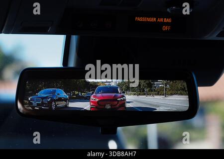 A digital rearview mirror display shows vehicles behind an Uber SUV, replacing a traditional mirror with a video projection. Stock Photo