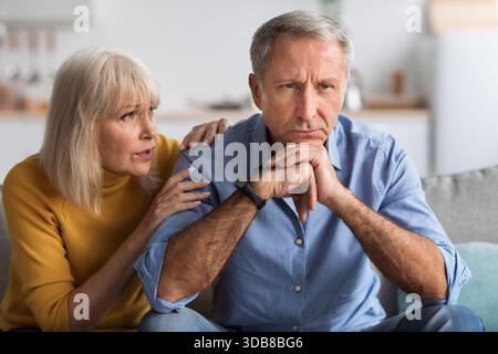 Senior Couple Having a Serious Conversation in Their Living Room During a Quiet Afternoon at Home Stock Photo