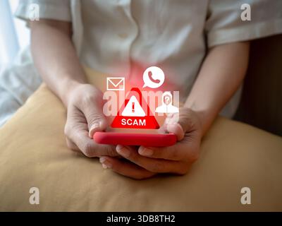 Person holding smartphone showing 3d red scam warning sign with scammer icon, calling and message symbols, representing mobile scam attacks, phishing, Stock Photo