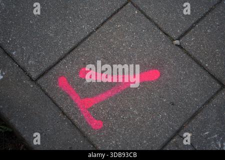 bright pink graffiti mark on grey cement tiles illuminating urban walkway with geometric patterns and textured surface, detail, uneven, contemporary, Stock Photo