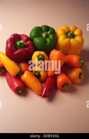 vibrant assortment of multicolored bell peppers and mini peppers arranged on a subtle beige background, highlighting freshness and variety, minimalist Stock Photo