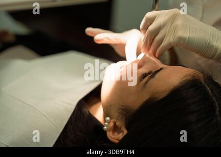 Dentist performing oral care procedure on patient in clinic Stock Photo