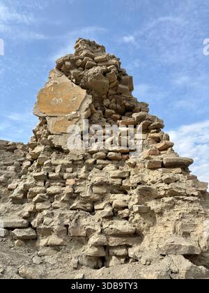 Close-up of crumbling ancient mud brick ruins against a blue sky. Stock Photo