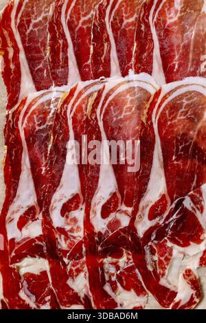 Thinly sliced Spanish Iberico ham Jamon Iberico paleta from front pork leg, close-up. Top view. Food background. Stock Photo