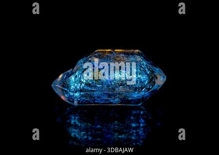 Closeup fluorescence glowing petroleum quartz (Enhydro/EnPetro Quartz)(quartz with hydrocarbon inclusions) under UV light on dark background Stock Photo