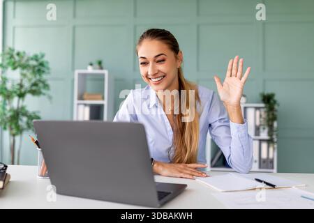 Happy Woman Participating in a Virtual Meeting at Home While Teaching Online Stock Photo