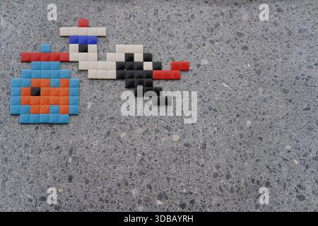 Colourful pixel art mosaic on a concrete pavement in Nantes, France, creating a playful piece of street art in an urban public space.Nantes,France Stock Photo
