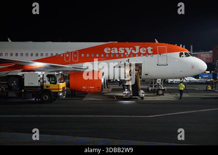 EasyJet passenger aircraft on the airport apron at night during ground operations and baggage loading.Nantes,France Stock Photo